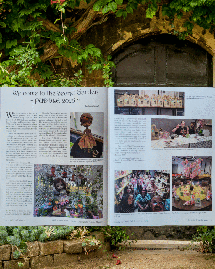 A garden door behind two pages of Doll Castle News magazine showing an article about PUDDLE 2025.